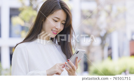 操作智能手機的婦女戶外 操作智能手機的婦女戶外 76501751