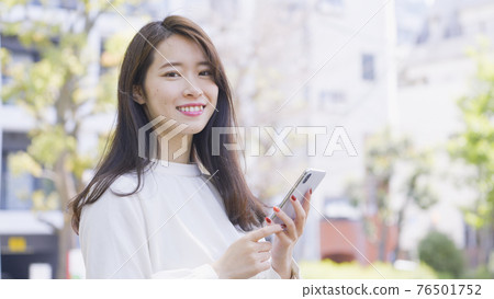 操作智能手機的婦女戶外 操作智能手機的婦女戶外 76501752