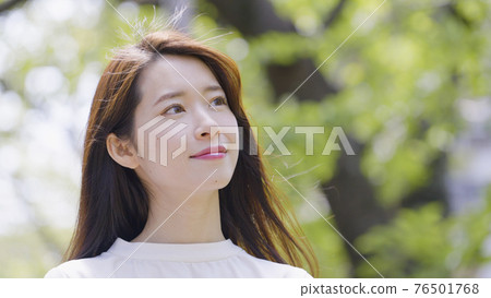 Young woman looking up outdoors Young woman looking up outdoors 76501768