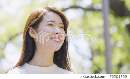Young woman looking up outdoors Young woman looking up outdoors 76501769
