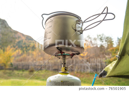 Travel cooking gears, pot and gas stove near camping tent in mountains, details, closeup Travel cooking gears, pot and gas stove near camping tent in mountains, details, closeup 76501905