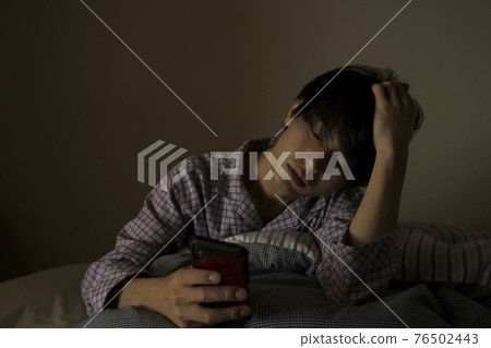 男人在床上看智能手機 男人在床上看智能手機 76502443