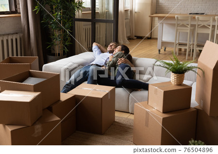 Happy relaxed family resting after moving day in new apartment Happy relaxed family resting after moving day in new apartment 76504896