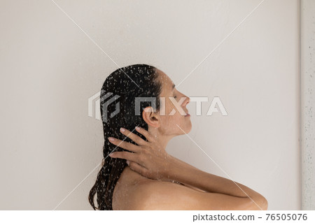 Side view beautiful woman standing under shower in bathroom 76505076