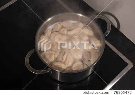 Cooking dumplings with meat by boiling in water in a pan, details, closeup Cooking dumplings with meat by boiling in water in a pan, details, closeup 76505473