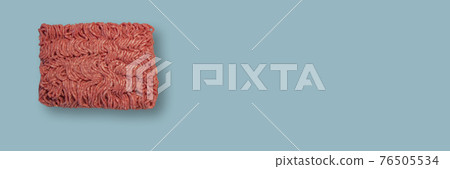 Banner with a brick of raw minced meat at light blue background with copy space, closeup, details. Concept healthy diet and nutritious food. 76505534