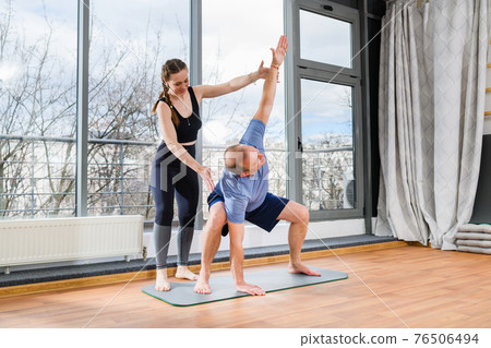 Mature man exercise yoga balance with trainer Mature man exercise yoga balance with trainer 76506494