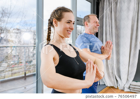 Smiling man and woman with namaste gesture Smiling man and woman with namaste gesture 76506497