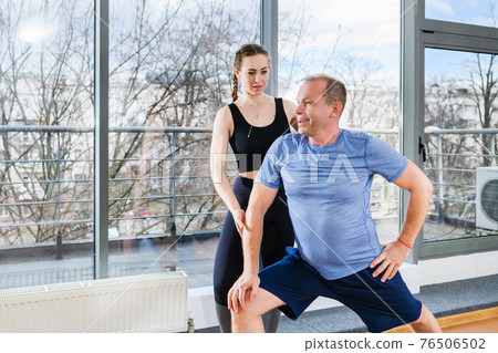 Female sport trainer exercise with mature man Female sport trainer exercise with mature man 76506502
