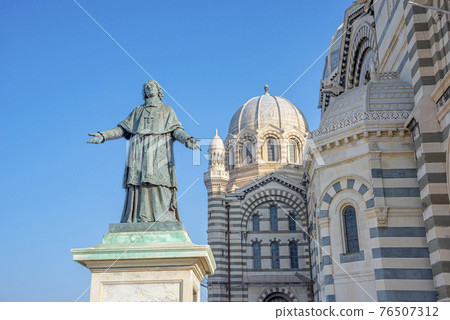 Statue of a Bishop Henri de Belsunce at magnificent Cathedral de la Major in Marseille illuminated with sunset at blue sky, Marseille, France, details, closeup. 76507312