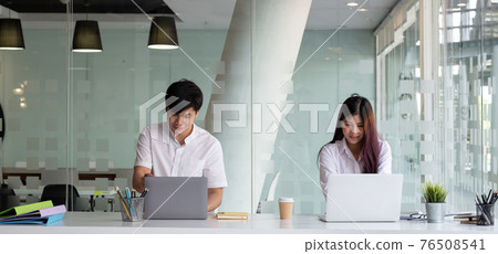 Two business people working with laptop computer at modern office 76508541