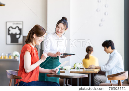 Staff serving young women ordering at the cafe Staff serving young women ordering at the cafe 76508551