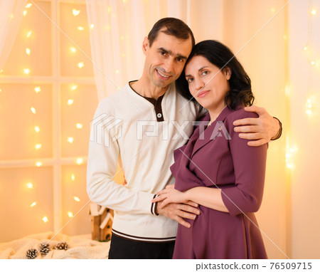 portrait of adult couple in home interior decorated with lights portrait of adult couple in home interior decorated with lights 76509715