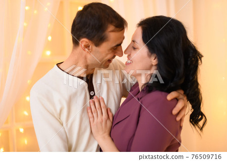 portrait of adult couple in home interior decorated with lights portrait of adult couple in home interior decorated with lights 76509716