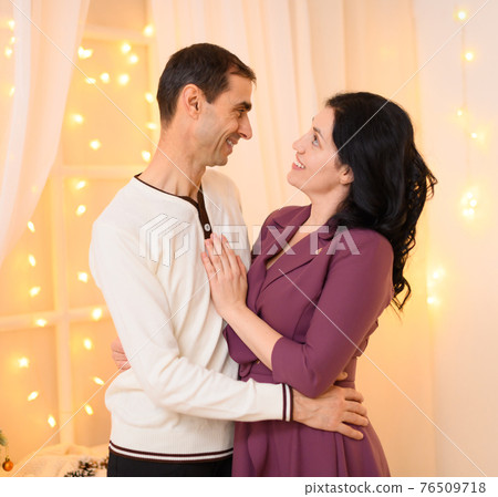portrait of adult couple in home interior decorated with lights portrait of adult couple in home interior decorated with lights 76509718