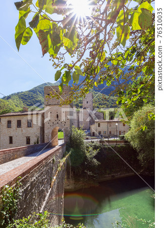 Beautiful view of Roman Catholic abbey (San Vittore alle Chiuse) from the medieval bridge. 76510035