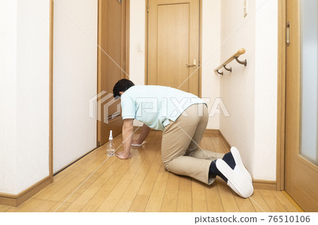 Back view of a house cleaning man wiping the flooring Back view of a house cleaning man wiping the flooring 76510106
