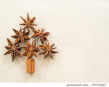 Cinnamon and star anise arranged in the shape of a tree 76510987