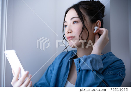 在智慧型手機上聽音樂的女人 76511055