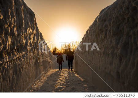 走在雪牆上的父母和孩子 76511370