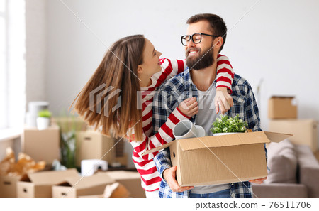 Cheerful couple with carton boxes together in new flat Cheerful couple with carton boxes together in new flat 76511706
