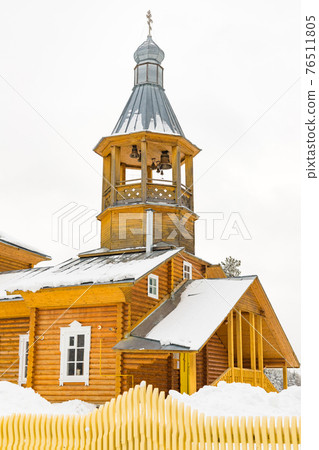 Wooden yellow color church with grey dome of Tarnogsky Gorodok village, Vologodskaya region, Russia 76511805