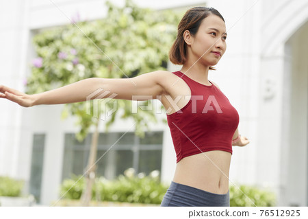 Sportswoman warming up Sportswoman warming up 76512925