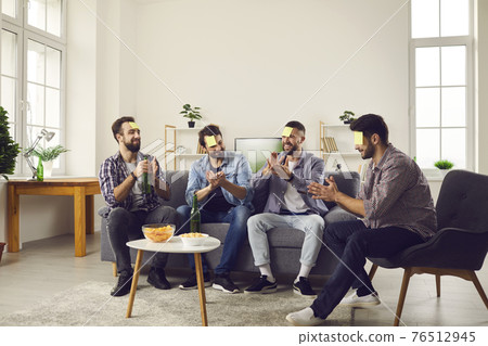 Smiling positive young men friends sitting and playing game with guessing words 76512945