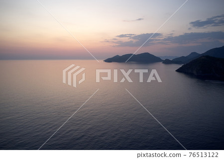 Evening sunset scenic view over sea and mountains. 76513122