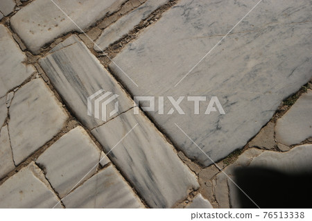 Cracked white marble stones on the ground of street road. Cracked white marble stones on the ground of street road. 76513338