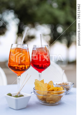 Two refreshing Italian cocktails with snacks on the table (Vertical photo) Two refreshing Italian cocktails with snacks on the table (Vertical photo) 76513462