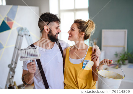 Couple having fun when painting wall indoors at home, relocation and diy concept. 76514809