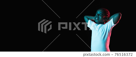 Portrait of little African-American girl isolated on dark background in neon 76516372