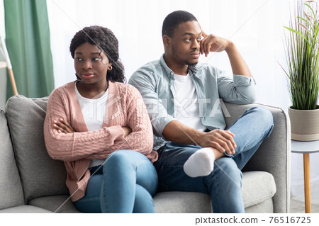 Angry black woman sitting apart from her frustrated boyfriend 76516725