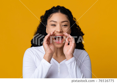 Young African American Woman Screaming Loud At Camera, Making Announcement 76516775