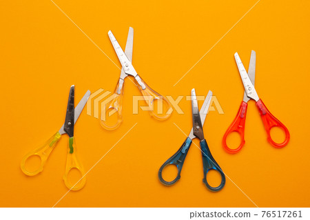 four color scissors for left-handers on a yellow background, as if moving up four color scissors for left-handers on a yellow background, as if moving up 76517261