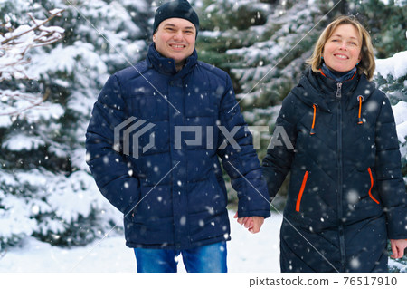 couple walking in a winter forest, two adult people, man and woman, beautiful nature with bright snowy fir trees couple walking in a winter forest, two adult people, man and woman, beautiful nature with bright snowy fir trees 76517910