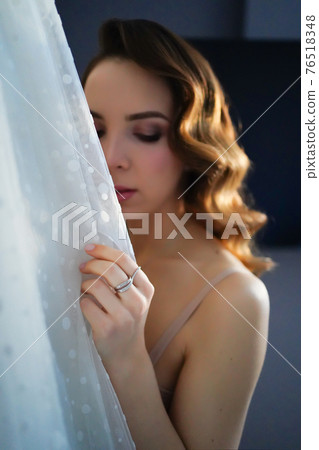 bride with long hair in underwear next to a white wedding dress bride with long hair in underwear next to a white wedding dress 76518348
