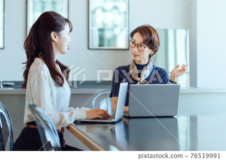 一位中年女商人在辦公室操作電腦時與下屬開會（休閒） 76519991