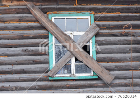 a boarded-up window of a wooden house with broken glass a boarded-up window of a wooden house with broken glass 76520314