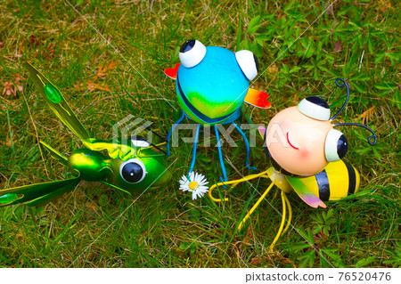 Tin statues of insects watching a daisy in meadow Tin statues of insects watching a daisy in meadow 76520476