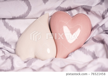 Two red hearts on a modern bedsheet Two red hearts on a modern bedsheet 76521458