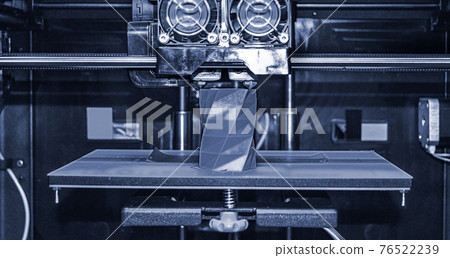 3D printer works and creates an object from the hot molten plastic 76522239