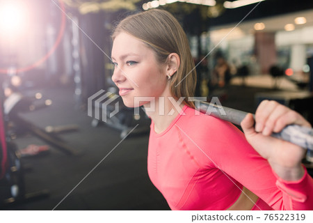 Beautiful muscular fit woman exercising, building muscles in gym Beautiful muscular fit woman exercising, building muscles in gym 76522319