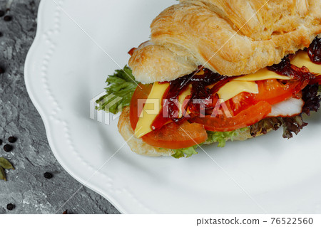 Delicious ham and cheddar cheese croissant with salad Delicious ham and cheddar cheese croissant with salad 76522560
