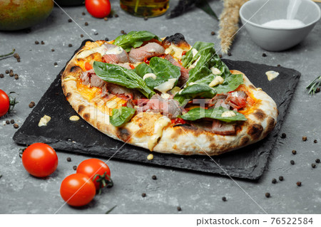 Meat Italian pizza with roast beef, steak slices, melted cheese, with olive slices and cheddar cheese. Close up, macro. Pizza time concept Meat Italian pizza with roast beef, steak slices, melted cheese, with olive slices and cheddar cheese. Close up, macro. Pizza time concept 76522584