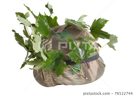 German Nazi Army steel helmet camouflaged with cover and tree leaves. World War II period 1933-1945. German Nazi Army steel helmet camouflaged with cover and tree leaves. World War II period 1933-1945. 76522744