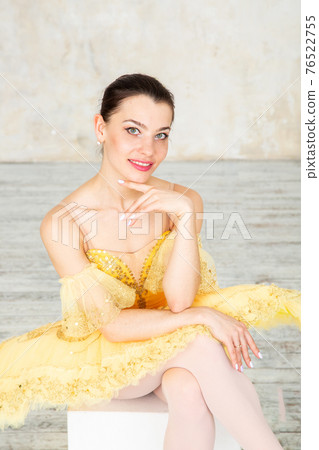 Young modern ballerina in yellow dress posing in the light ballet room 76522755