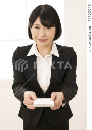 年輕女子穿著西裝展示名片(正面) 年輕女子穿著西裝展示名片(正面) 76522948