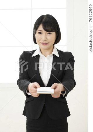年輕女子穿著西裝展示名片(正面) 年輕女子穿著西裝展示名片(正面) 76522949